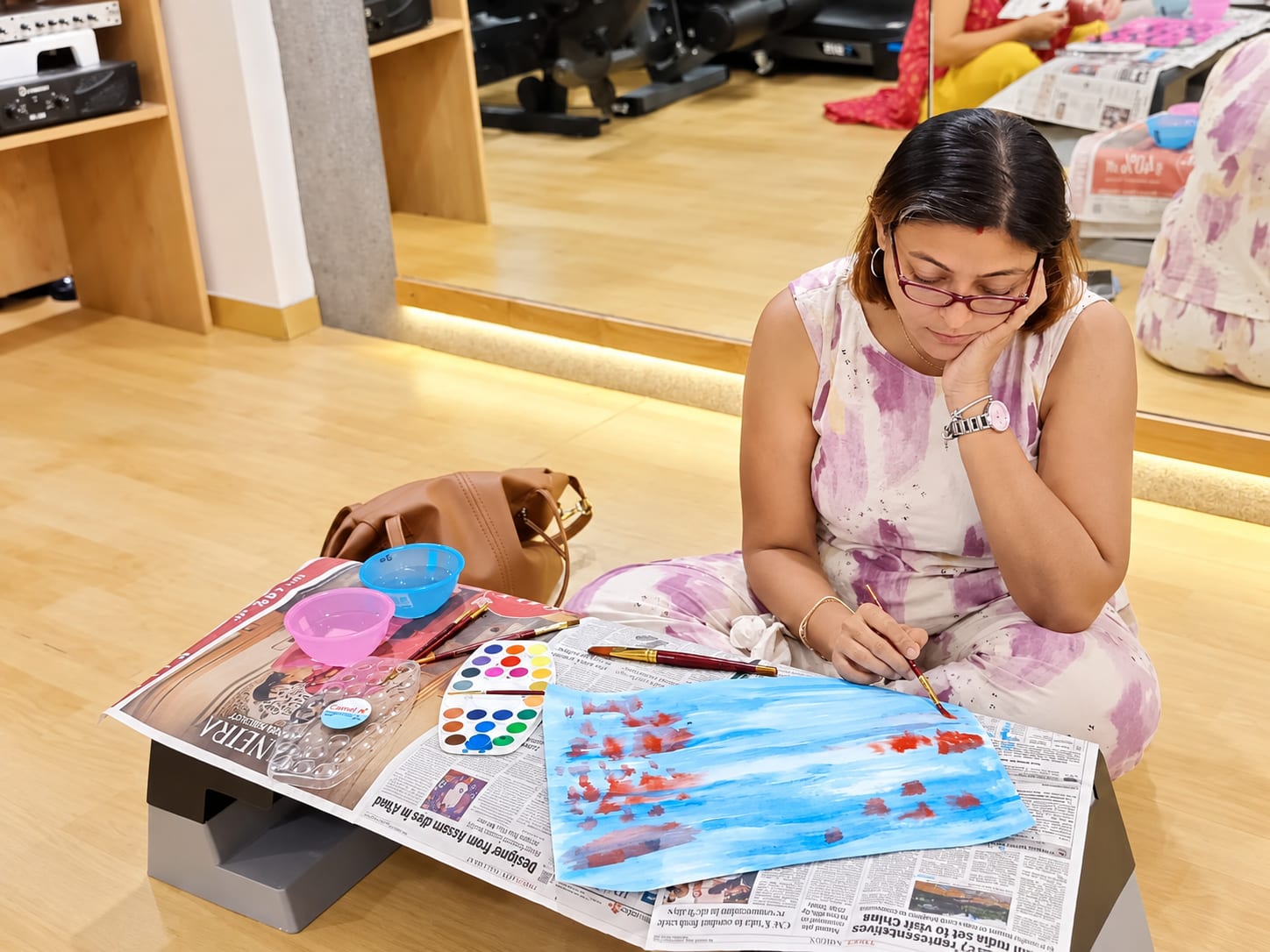 An adult painting in watercolour during an arts based therapy session at Jatan