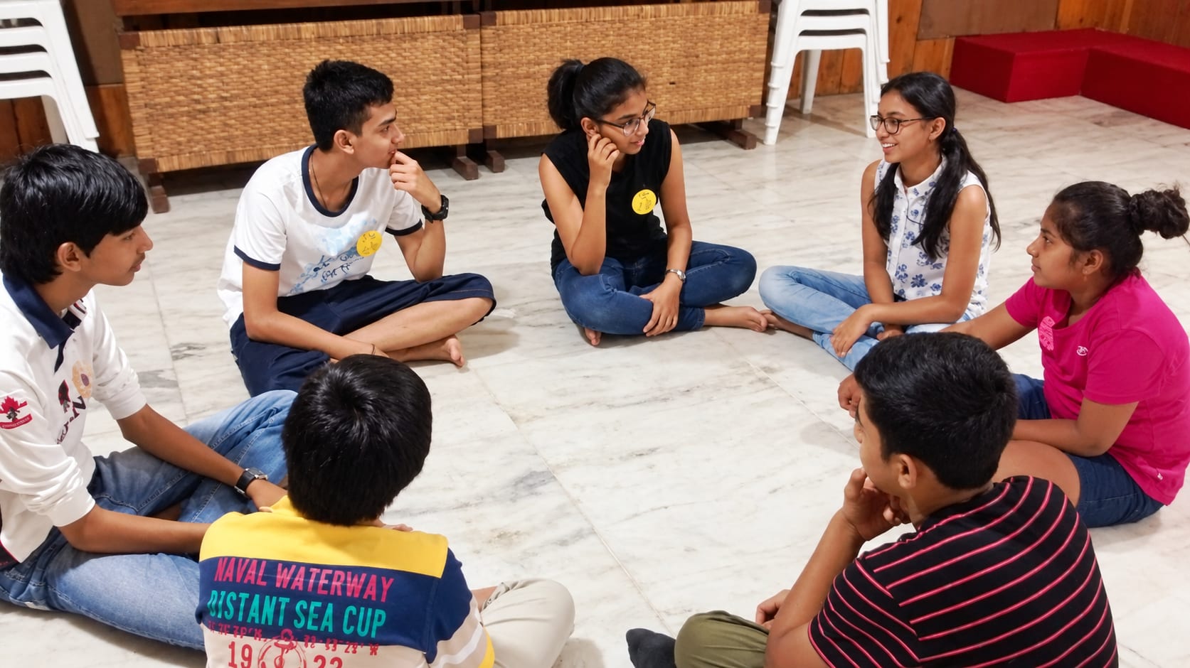 Teenagers sitting in a circle on the floor during a group session at Jatan